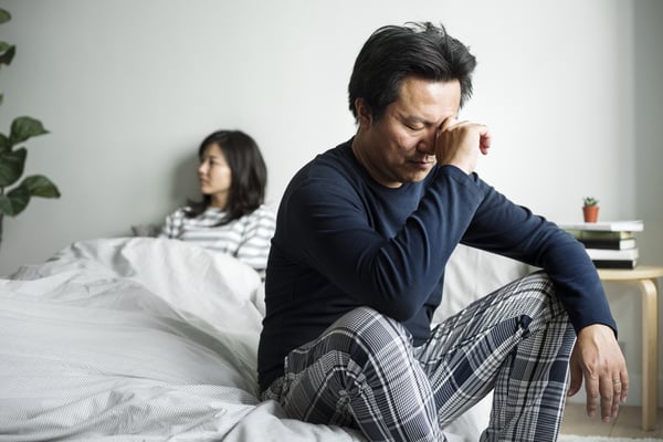 unhappy Asian couple in bed